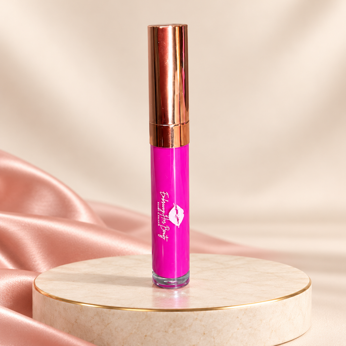 Berry Fearless liquid lipstick in its original rose-gold tube on an ivory pedestal with blush satin