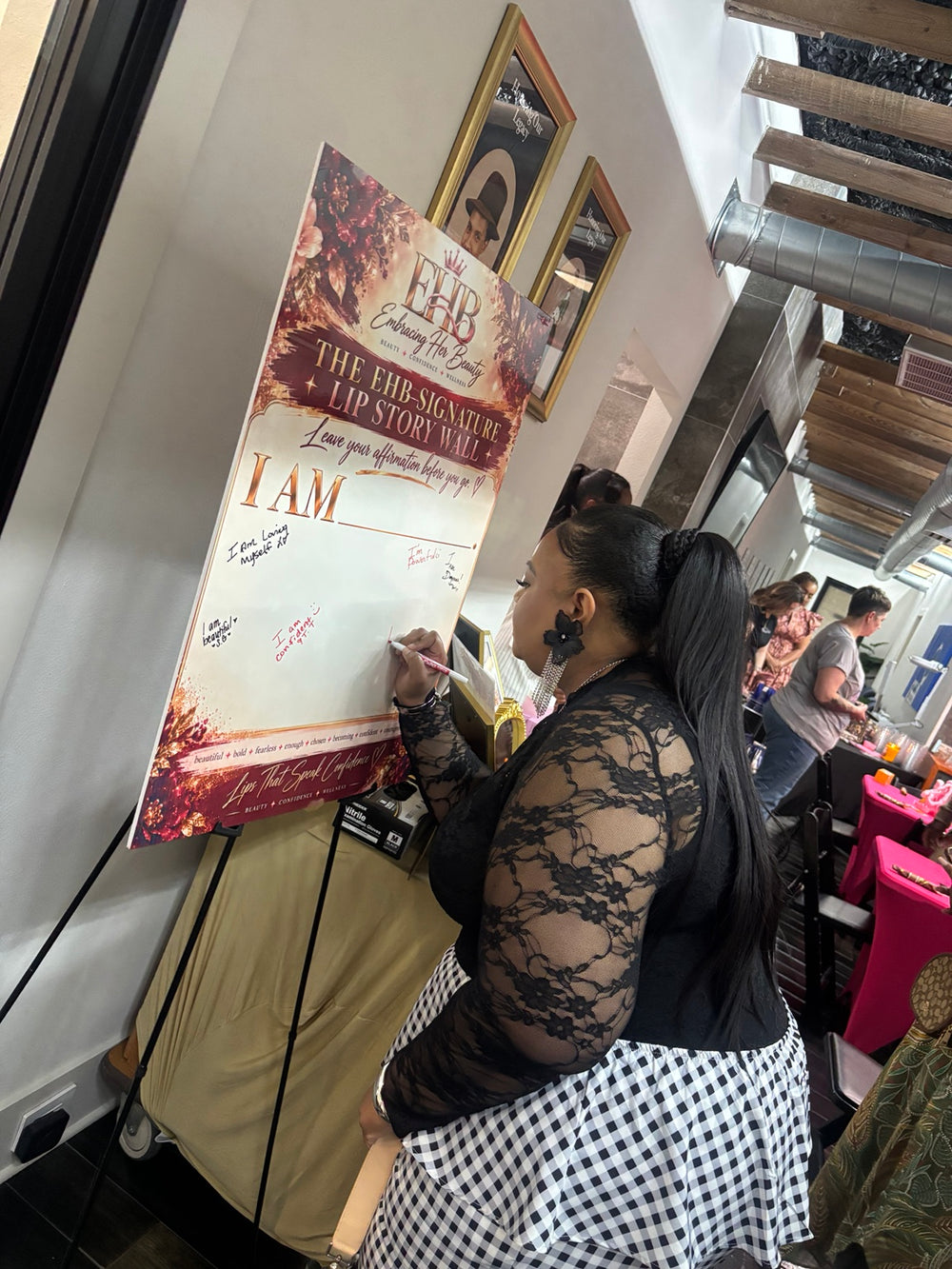 Signature Lip Bar guest writing an affirmation on the Lip Story Wall