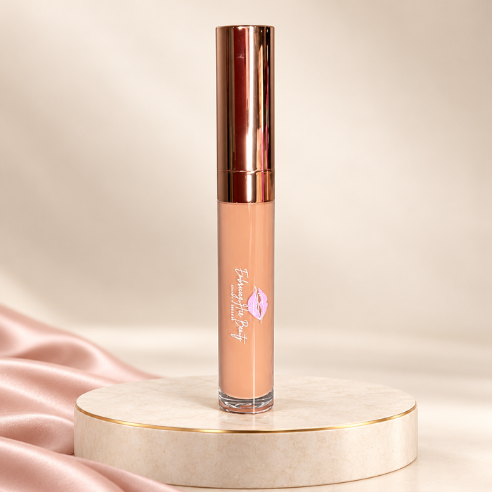 Top Tier liquid lipstick in its original rose-gold tube on an ivory pedestal with blush satin